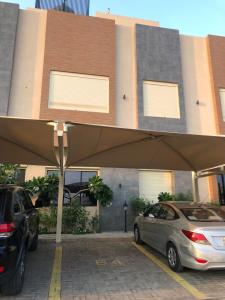 two cars parked in a parking lot in front of a building at Smart luxury apartment 3bedrooms in Riyadh