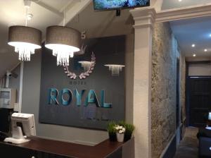 un vestíbulo con dos lámparas de araña y un cartel real en la pared en Royal Porto City, en Oporto