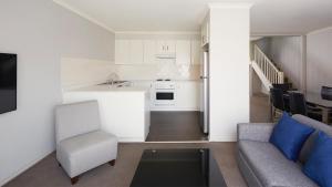 a kitchen and living room with a couch and a table at Pinnacle Apartments in Canberra