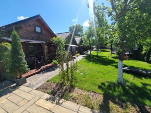 a garden with a house and a tree in the yard at Domki i dom w sadzie Stegna z podgrzewanym basenem - prywatne jacuzzi przy domu in Stegna