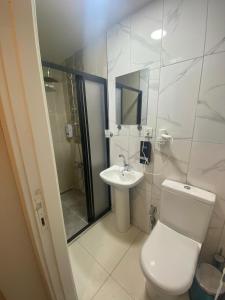 a white bathroom with a toilet and a sink at Kadıköy Bull Hotel in Istanbul