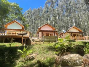 a couple of cottages in front of a mountain at Pousada Villa Del Bosque in Monte Verde