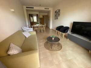 a living room with a couch and a television at Relax House Murcia in Fuente-Álamo de Murcia
