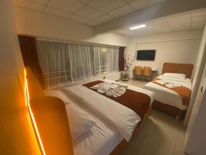 um quarto de hotel com duas camas e uma televisão em Kadıköy Bull Hotel em Istambul