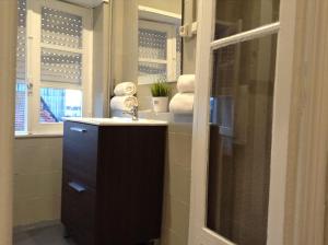 Un baño con lavabo, espejo y toallas. en Royal Porto City, en Oporto