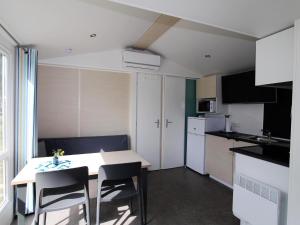 a small kitchen with a table and chairs in a room at Mobile Home an der Drau in Sachsenburg
