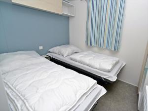 two beds in a hospital room with white sheets at Mobile Home an der Drau in Sachsenburg
