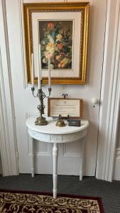 uma mesa branca com velas e uma pintura na parede em The 1885 Suites em Picton