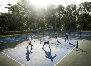 a group of people playing tennis on a tennis court at Direct ocean front condo in Royale Palms, 801 condo in Coffeyville