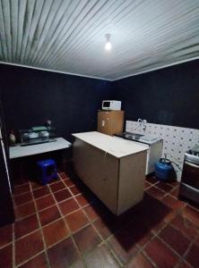 eine Küche mit einer Theke und einem Herd in der Unterkunft Hostel Cápsula Pousada Avenida G20 in Canoinhas