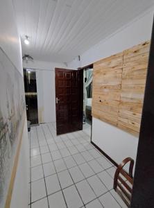 Zimmer mit Holztür und Fliesenboden in der Unterkunft Hostel Cápsula Pousada Avenida G20 in Canoinhas