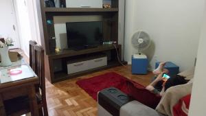 uma pessoa sentada num sofá numa sala de estar em Apartamento Centro do Rio no Rio de Janeiro