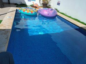 a swimming pool with two inflatable boats in the water at Private pool villa with jacuzzi, near beaches in Punta Cana +28 photos