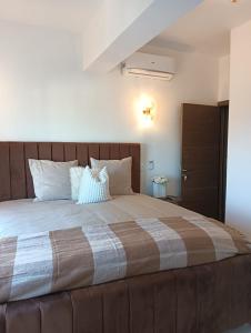 una camera da letto con un grande letto con cuscini bianchi di Rental house Santo Domingo a Santo Domingo