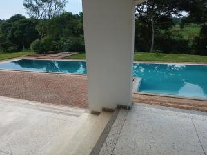 uma vista para uma piscina a partir do alpendre de uma casa em Grand Grove Villa em Jinja
