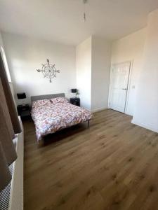 a bedroom with a bed and a wooden floor at Cosy 3 bedroom flat in Chatham in Chatham +5 photos