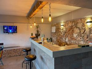 a bar in a restaurant with a stone wall at Apartments by the sea Lumbarda, Korcula - 4385 in Lumbarda