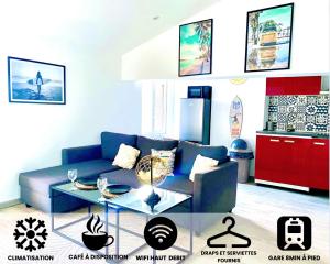 a living room with a blue couch and a table at Appartement Climatisé & wifi Béziers - Surfer Paradise in Béziers