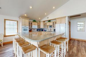 a kitchen with a large island with bar stools at Down by the Sea #15-H in Hatteras
