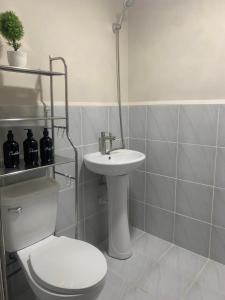 a white bathroom with a toilet and a sink at RF Condotel in Lapu Lapu City