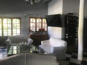 查克拉斯德科里亞的住宿－Posada Pinar De Besares，客厅配有白色的椅子和桌子