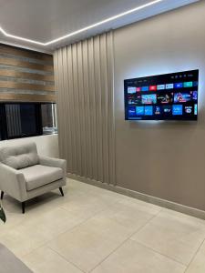 una sala de espera con una silla y una TV en la pared en Hotel Amazonas Suite, Suite Presidencial en Nueva Loja