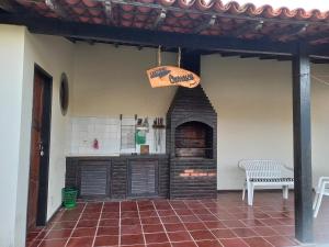 una habitación con chimenea en una casa con banco en Cantinho da Lagoa, en Araruama