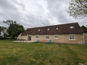 une maison avec deux chaises bleues dans une cour dans l'établissement Grande Maison de Campagne avec Jardin Clos, Proche Levroux, 12 Pers., Châteaux, Zoo de Beauval - FR-1-591-176, à Levroux