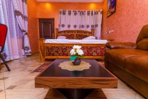 - un salon avec un lit, un canapé et une table dans l'établissement Kobby Keach K Hotel, à Kumasi