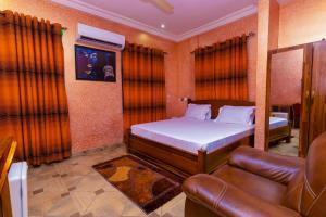 1 dormitorio con 1 cama y 1 sofá en Kobby Keach K Hotel en Kumasi