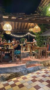 a group of people sitting at tables in a restaurant at La Boheme Bajo in Labuan Bajo