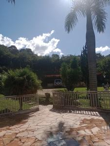 a gate with a palm tree in the background at Pousada nossa senhora in Aiuruoca