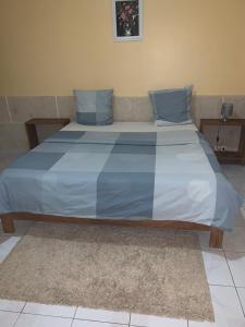 una cama con almohadas azules en una habitación en Thiossane, en Saint-Louis