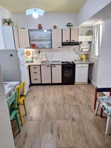 a kitchen with white appliances and wooden floors at Apartments by the sea Punat, Krk - 19831 in Punat