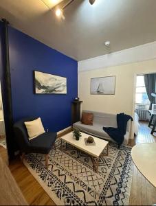 a living room with a couch and a blue wall at The 30 Day Stay Vibrant House in New York