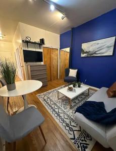 a living room with a table and a blue wall at The 30 Day Stay Vibrant House in New York