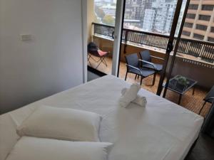 a white bed with a teddy bear on top of it at Accommodation Sydney City Centre 1 Bedroom Apartment with Balcony in Sydney +7 photos