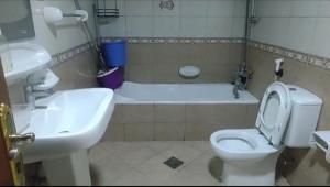 uma casa de banho com um lavatório, um WC e uma banheira em Biggest Room in Sharjah em Sharjah