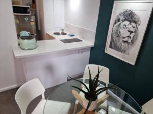 a dining room with a glass table and a lion picture at Accommodation Sydney City Centre 1 Bedroom Apartment with Balcony in Sydney