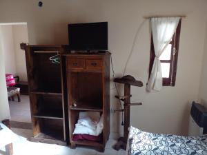 a living room with a tv on a wooden cabinet at Cabaña Guerrero in Tilcara