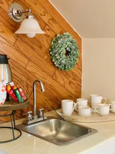 un fregadero con tazas y una corona en la pared en The Heritage Suite at The Historic Kanab Inn, en Kanab