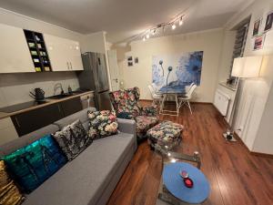 Apartament WILDA في بوزنان: غرفة معيشة مع أريكة وطاولة