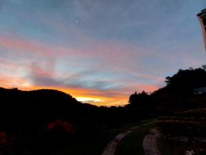 un coucher de soleil avec un chemin de terre au premier plan dans l'établissement Belcruz family lodge, à Monteverde Costa Rica