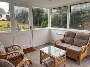 a living room with a couch and chairs and windows at Shared House in central location Inverness in Inverness