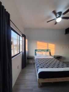 een slaapkamer met een bed en een plafondventilator bij KAVA lofts in El Pueblito