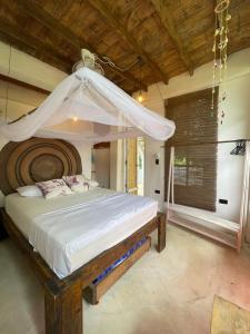 1 dormitorio con 1 cama grande con dosel en Jumanji, en Palomino