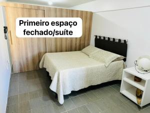 um quarto com uma cama e uma placa que lê primatio papaya feltado em Confortável Apto com Manobrista Wi-fi - Tv Smart - piscina - Apto 703 em Maceió