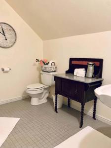 a bathroom with a toilet and a sink and a clock at The Founders Suite at The Historic Kanab Inn in Kanab +11 photos