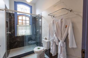 a bathroom with a shower and a toilet at Pousada Pequena Tiradentes in Tiradentes