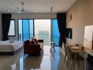 a bedroom with a bed and a living room with a view at Trefoil Studio Comfy 3-Shah Alam in Shah Alam